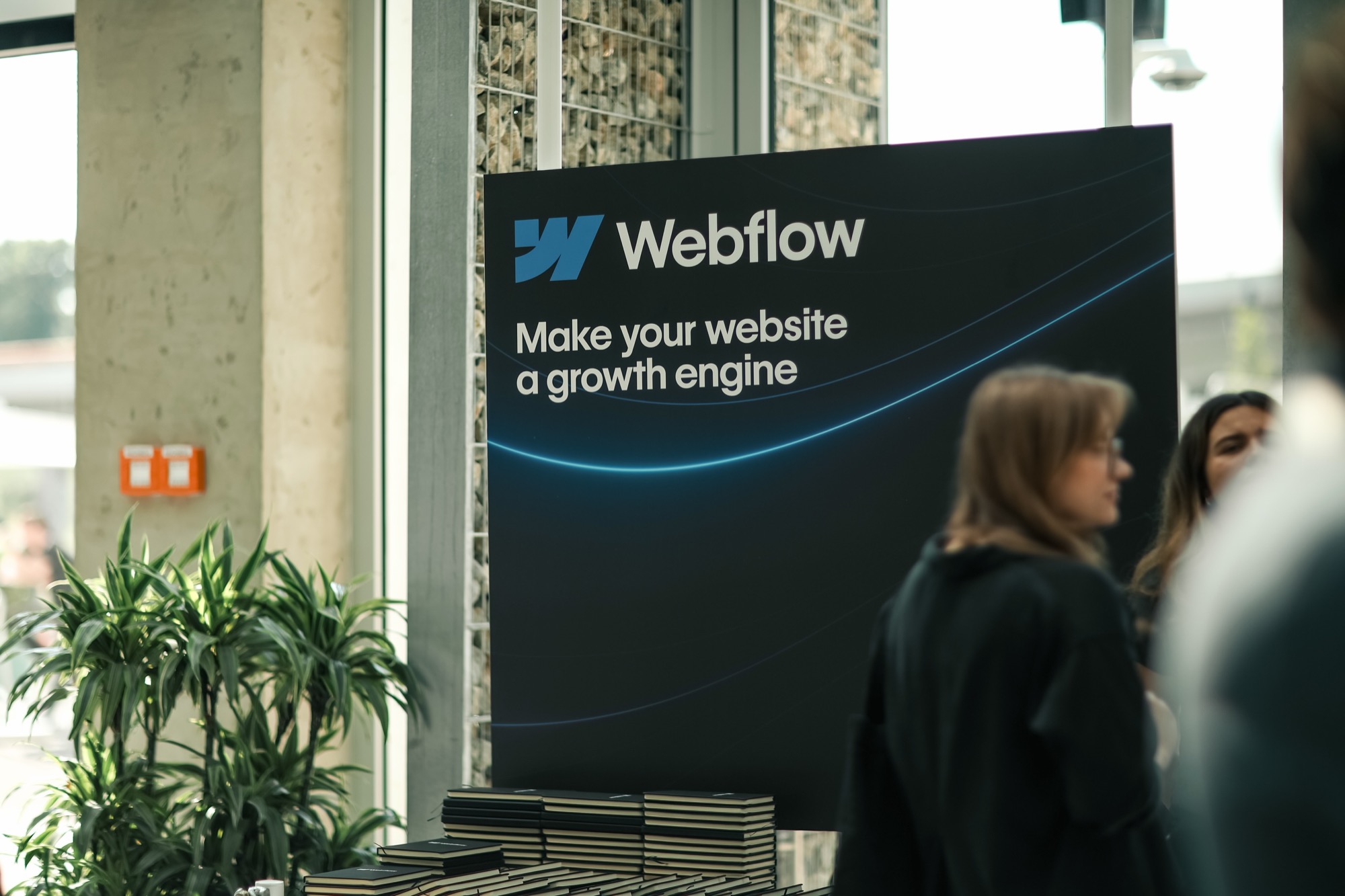 The Webflow stand in the foyer, its board reading "Make your website a growth engine".