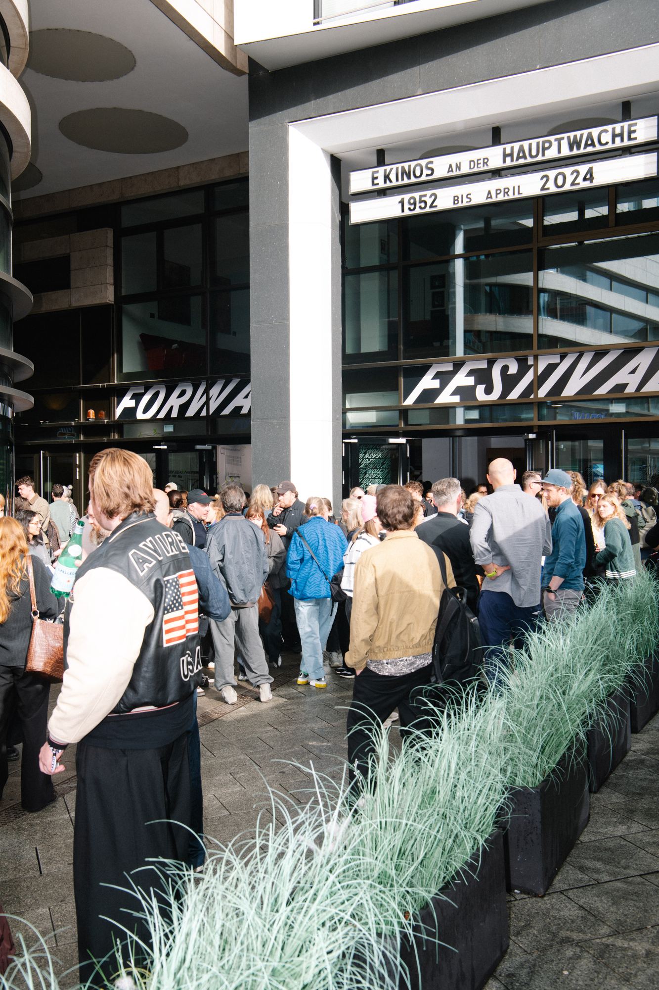 Festival-goers waiting outside the Frankfurt venue, under the Forward Festival lettering across the glass.