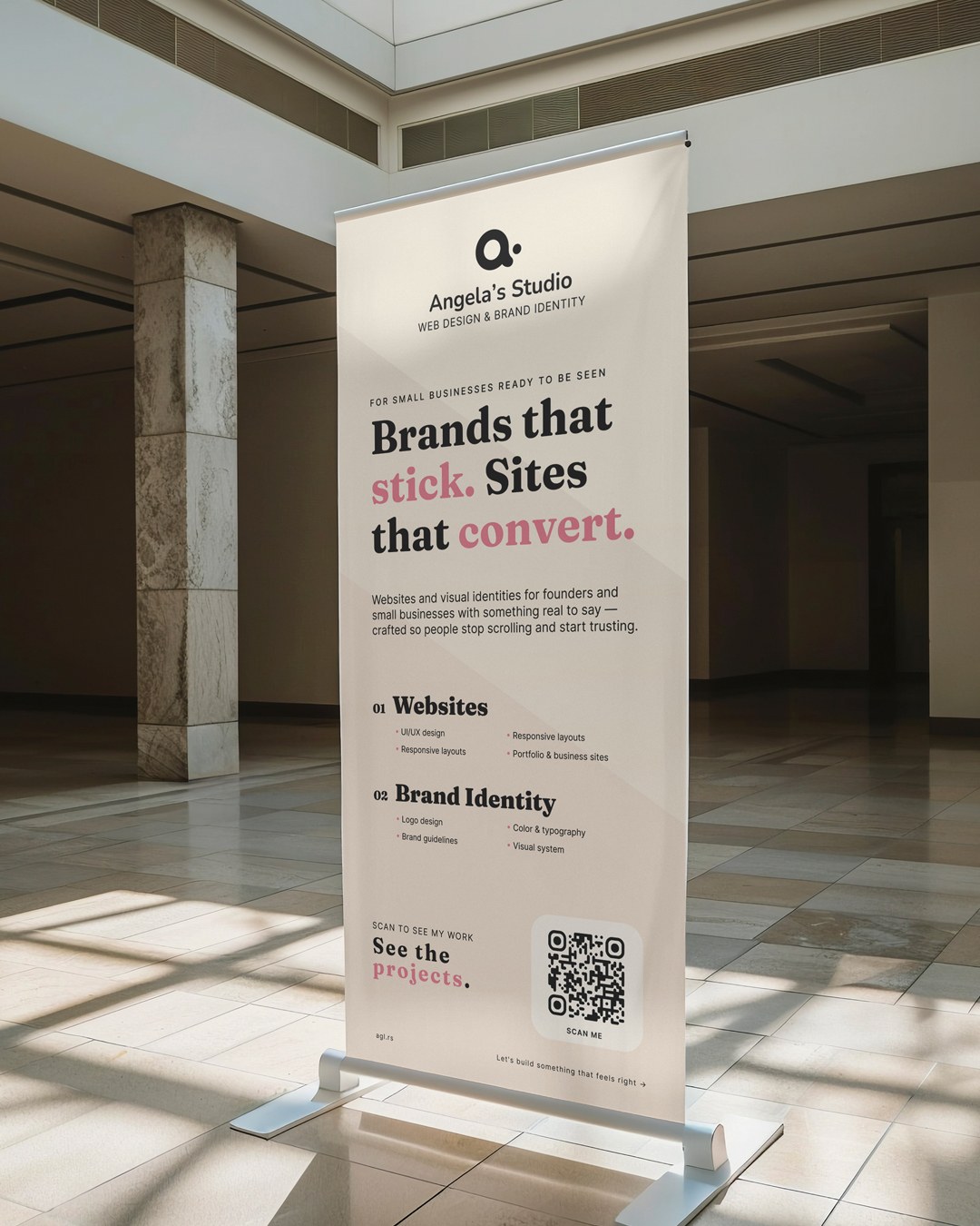 The studio roll-up banner standing in daylight — "Brands that stick. Sites that convert." over the two service lists and a QR code at the foot.